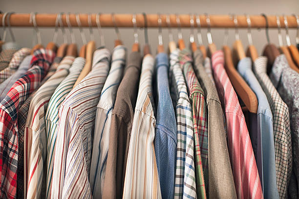 Shirts on Hangers A variety of shirts hanging on a wooden clothes rack. mens fashion stock pictures, royalty-free photos & images