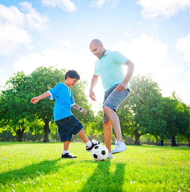 istock Father and son playing football together 155392439