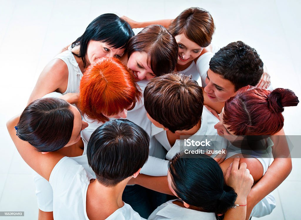 Partnership Group of happy women standing together in the circle, embracing and looking at each other. Elevated view. Adult Stock Photo