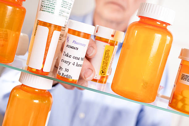 receta hombre tomando píldoras de armario de aseo personal - ishealth2012 health care industry medicine fotografías e imágenes de stock