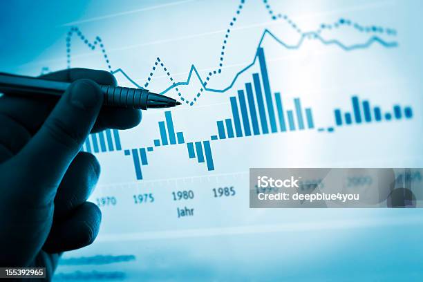 Hand Pointing With Pen On A Computer Chart Document Stock Photo - Download Image Now