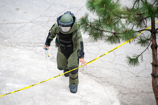 Bomb disposal expert crossing the security tape