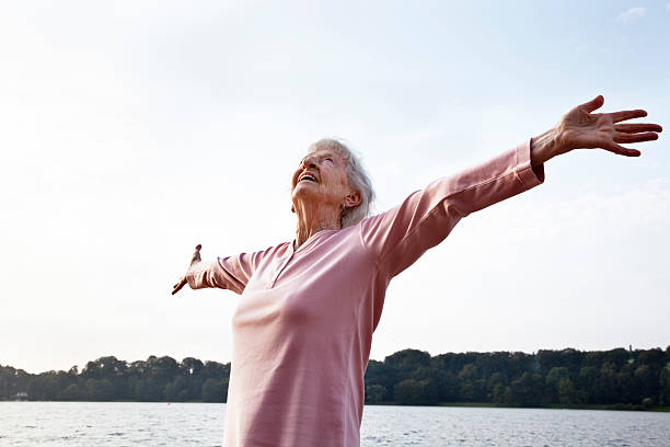 senior woman enjoying life senior woman, 88 years old, very active and flexible, enjoying life at a lake at a sunny summer morning,doing breathing exercises rhineland stock pictures, royalty-free photos & images