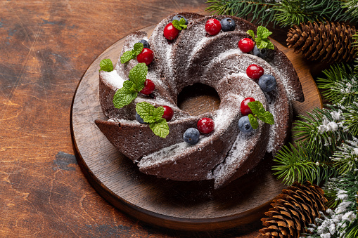 Christmas cake decorated with blueberry, cranberry and mint. With copy space