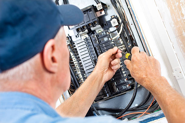 Electrician doing electrical work in breaker box stock photo