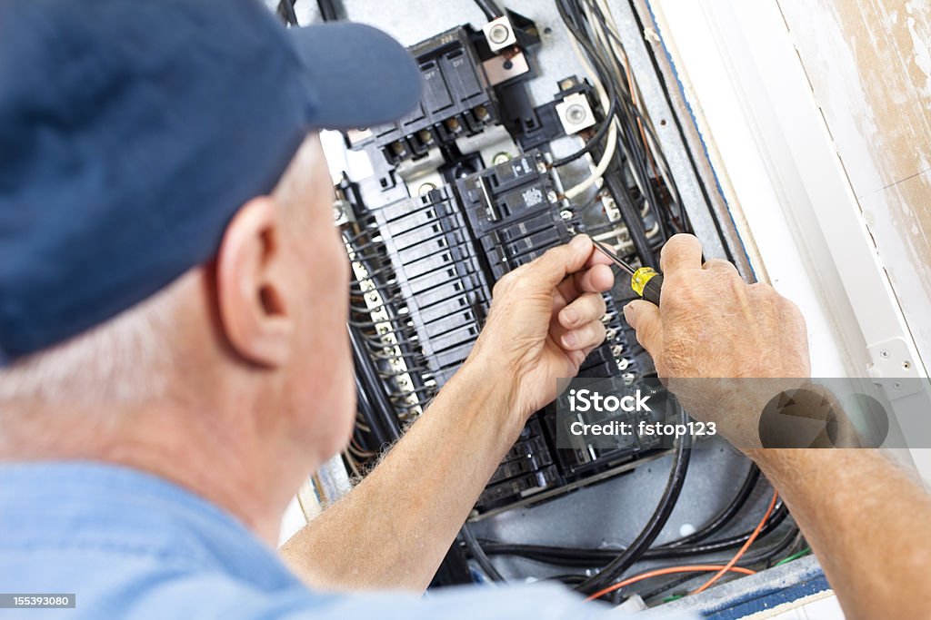 Eletricista fazendo de Trabalho elétrico na caixa do disjuntor - Foto de stock de Eletricista royalty-free