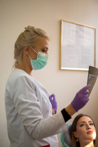 istock Dentist examining x-ray on patient in dental clinic 1553930811