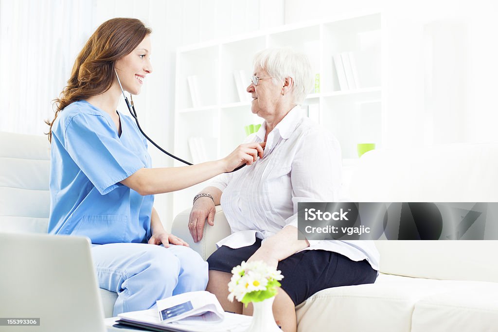 Donna anziana a medici in ufficio. - Foto stock royalty-free di Accudire