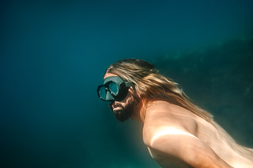 Portrait of a diver in a deep dark water