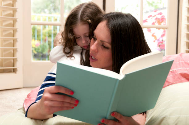 istock Mom Reads Daughter To Sleep 155393416
