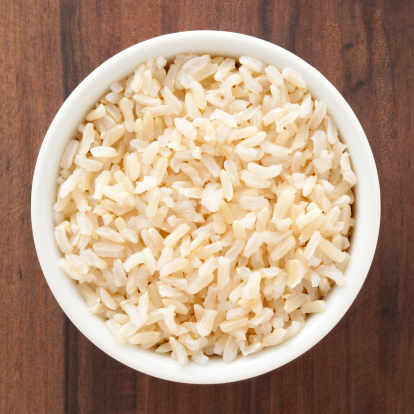 Top view of white bowl full of boiled brown rice