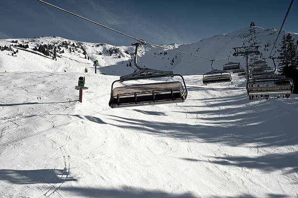 Chair Lift Kitzb&#252;hel Mountain Resort Alpine Ski Piste with Snowgun stock photo