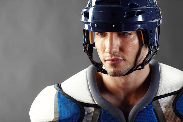 istock Hockey player in padded uniform with helmet looking away 155393865