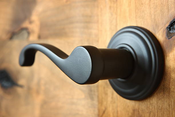 Doorknob Lever Handle Home Decor Doorknob - lever styled handle - matte black finish - on solid knotty alder wood door. latch stock pictures, royalty-free photos & images