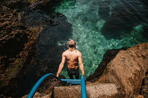A man holding on sea ladders and soaking sun.  Hidden natural beauties, Albatros Montenegro