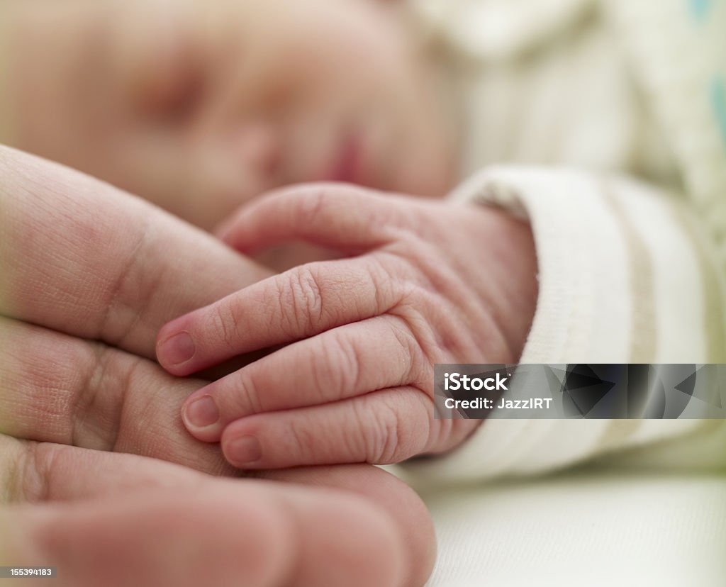 Baby holding adult finger Generations Newborn Stock Photo