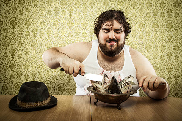 istock Large fat man eating fish head soup at wood table 155394377