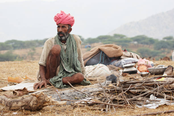 istock Bedouin asian man squatting in desert 155394496