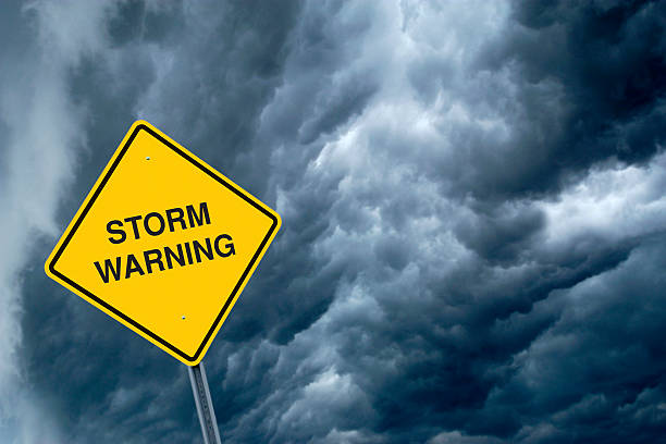 istock A yellow storm warning sign with storm clouds behind  155394646