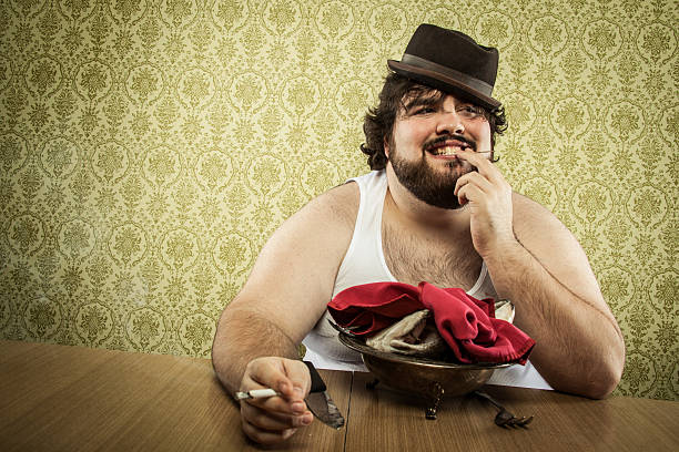 istock fat man finishing eating fish head soup at wood table 155394758