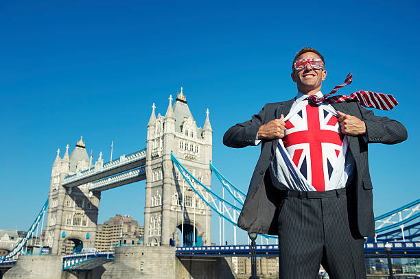 sorridente uomo d'affari supereroe con bandiera britannica unione jack london tower bridge - british flag flag london england england foto e immagini stock