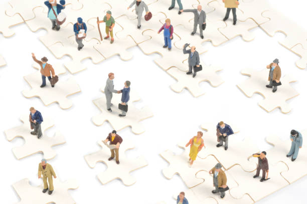 istock Little people on puzzle pieces shaking hands and isolated 155395068