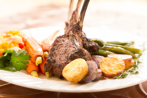 Sliced Rack of Lamb with Carrots and Green Beans on a white plate