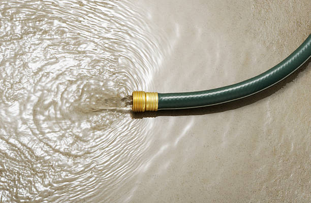 Wasting water Gardening hose on concrete floor without water gun, wasting water concept.  More pictures... hose stock pictures, royalty-free photos & images