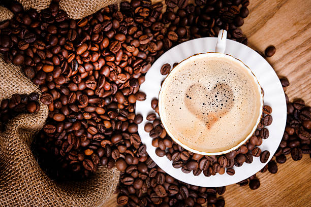 morning coffe morning coffee cup with heart shape and coffee beans near jute bag. milk froth stock pictures, royalty-free photos & images