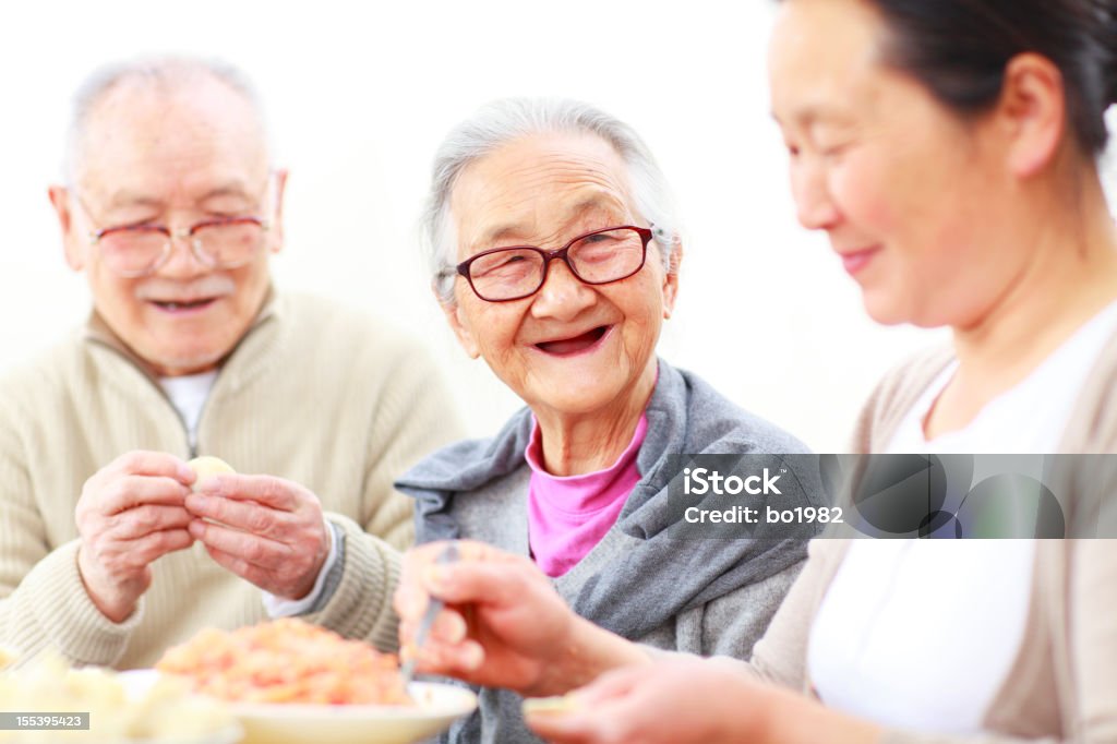 Raviolis chinois en famille heureux ensemble - Photo de 50-54 ans libre de droits