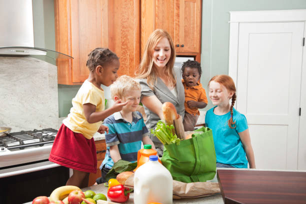 istock mother and children unbagging groceries in kitchen 155395521