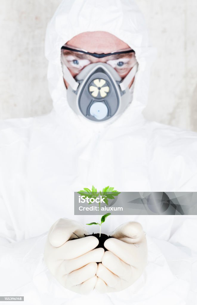 Genetic research Scientist in white protective suit and holding plant Adult Stock Photo