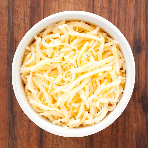 Grated cheese Top view of white bowl full of grated cheese mozzarella stock pictures, royalty-free photos & images