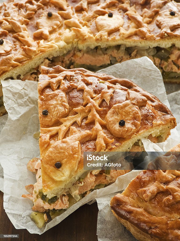 Salmon pie Freshly baked salmon pie wrapped in paper. Shallow dof. Baked Stock Photo