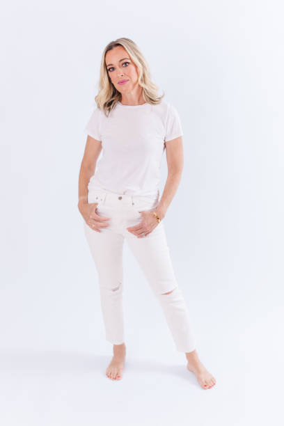 istock Blonde woman sitting against white background 1553972585