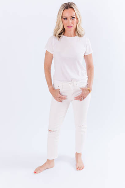 istock Blonde woman sitting against white background 1553972587