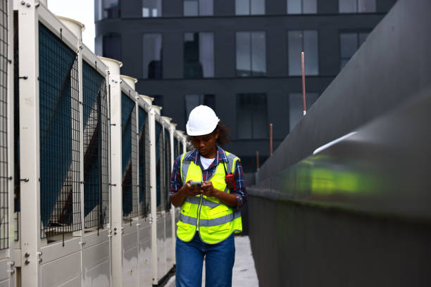 istock Female environment engineer with safety uniform with walkie-talkie using a smartphone working on the sideline 1553981967