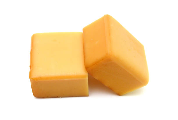 istock Cubes of cheddar cheese isolated on white 1553988889