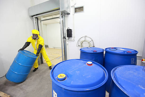 Worker rolling the barrel with toxic substance stock photo
