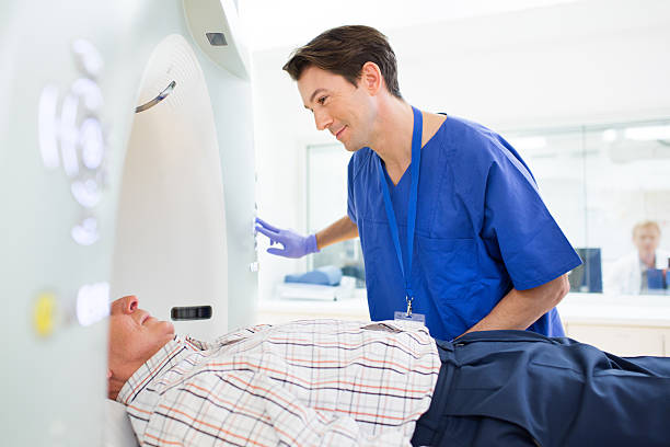 Patient and Doctor in CAT Scan Patient and Doctor in CAT Scan ambulant patient stock pictures, royalty-free photos & images