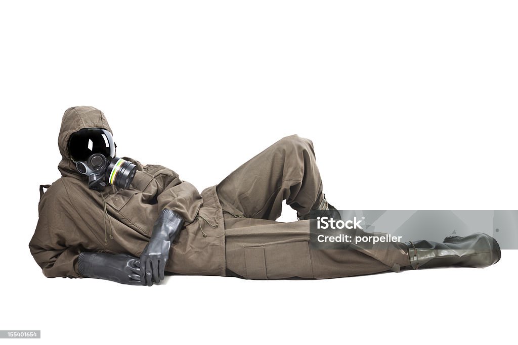 Man in Hazard Suit layng on the ground A man wearing an NBC Suite (Nuclear - Biological - Chemical) Radiation Protection Suit Stock Photo