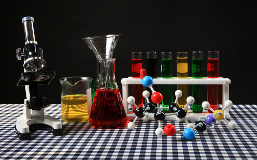 Education Laboratory, Set of glass for trial Science with the test tube, Begerglass, conical flask with the colorful  solution chemical   and microscope on the table in black background