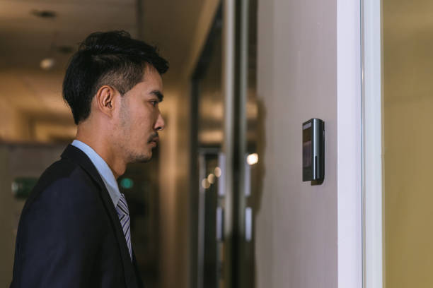istock Man using face scanner to unlock door in office building. Access control facial recognition system. Biometric admittance control device for security system. Biometric admittance control device 1554094712