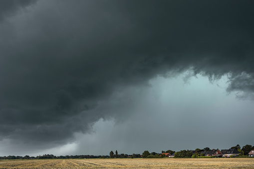 shot of green field with dramatic rainy clouds