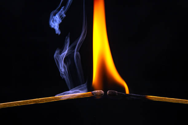 istock Fire and smoke. Burning and smoking match on a black background. Heat and light from fire flame 1554142068
