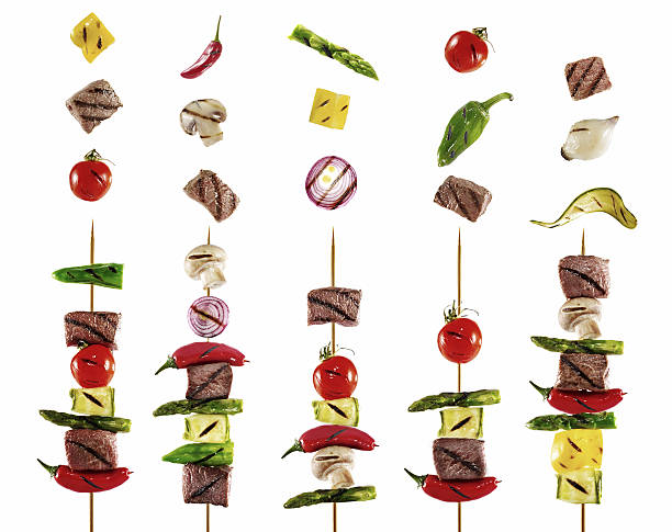 Shish kebabs Skewered shish kebabs and vegetables on white background shish kebab stock pictures, royalty-free photos & images