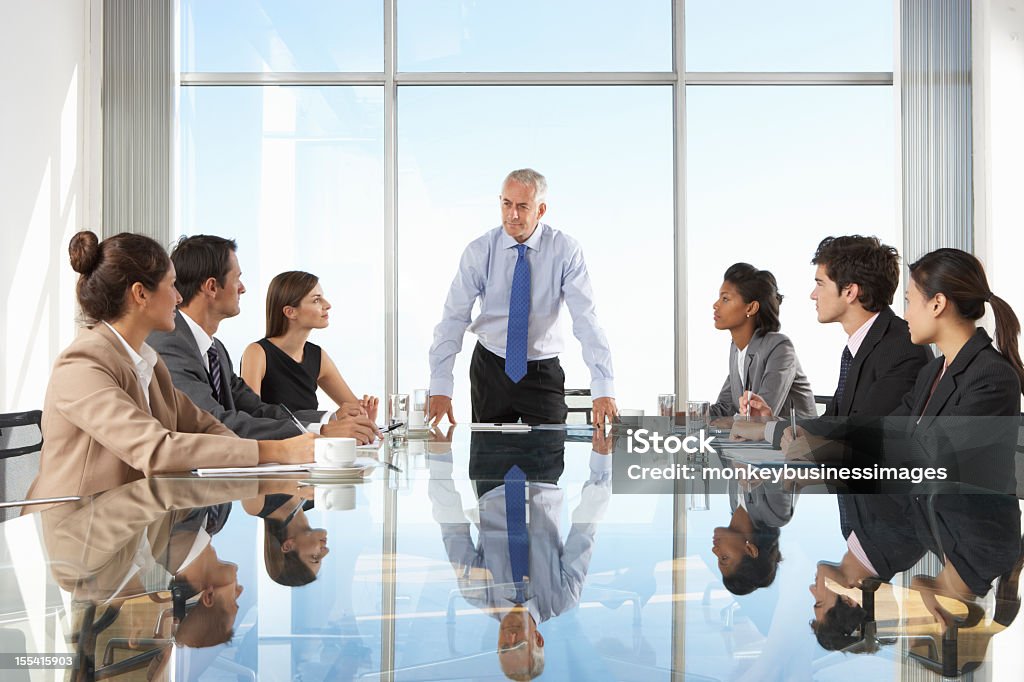 Group Of Business People Having Board Meeting Group Of Business People Having Board Meeting Around Glass Table. Meeting Stock Photo