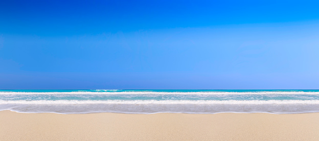 Waves, sand and sky in a tropical beach background. Relaxing images of travel and leisure related vacation themes for vacations in the Caribbean. Image taken at Morrocoy National Park, Venezuela. Morrocoy is a coastline and a group of small islands and cays located at Falcon State in Venezuela. A very popular destination for leisure, diving, kite surfing and all kind of water activities. Morrocoy and the beauty of the turquoise coastal beaches of Venezuela are almost indistinguishable from those of the Bahamas, French Polynesia, Malau, Hawaii, Cancun, Costa Rica, Florida, Maldives, Cuba, Fiji, Bora Bora,  Puerto Rico, Honduras, or other tropical vacation travel destinations.