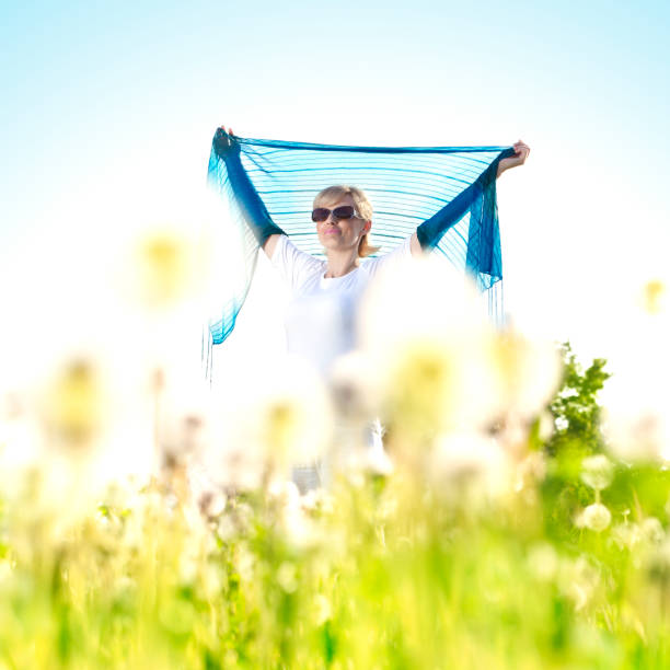 Young girl outside blowing dandelion-copyspace