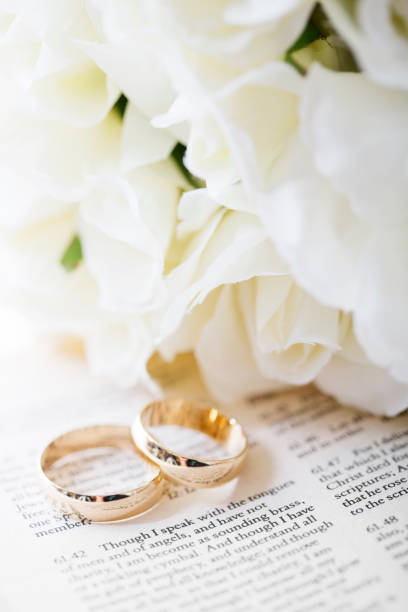 Bible passage from Corinthians, a bridal bouquet and wedding rings